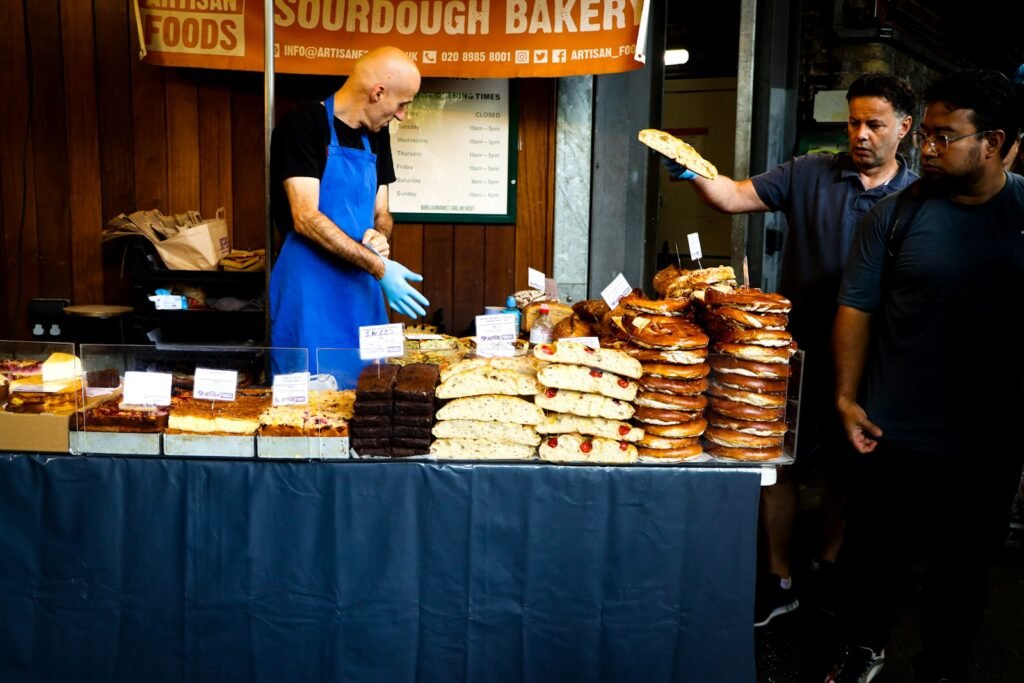 Baker serving pastries at a market stall